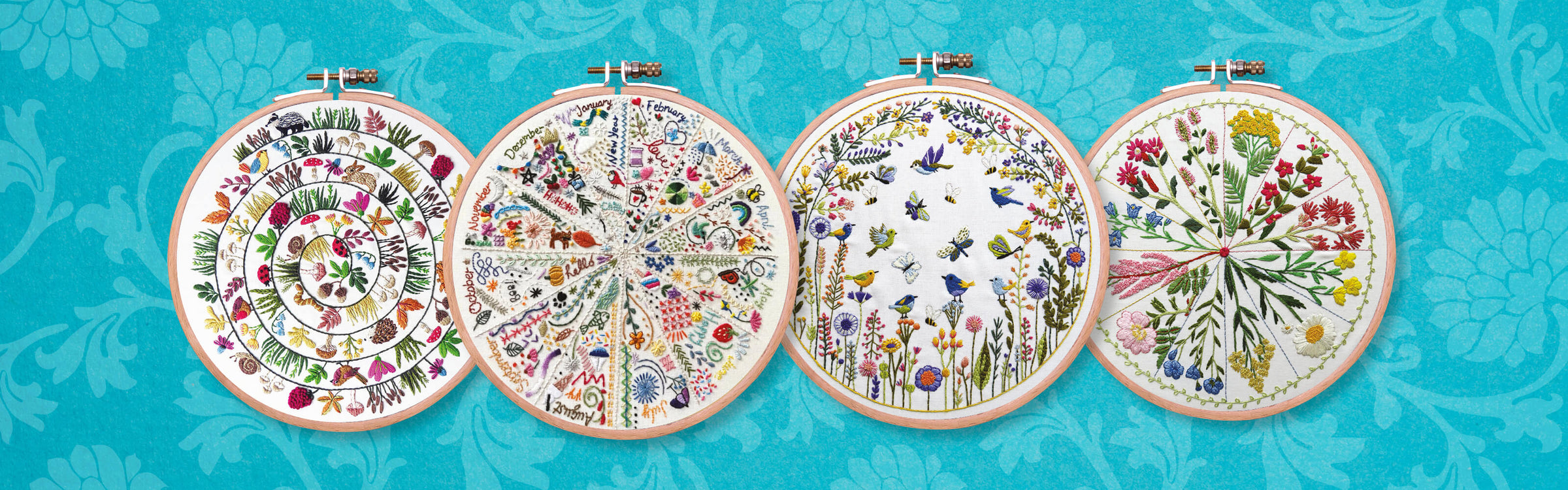 Four embroidery hoops with floral patterns on a blue floral background