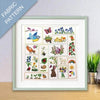 Framed fabric pattern with colorful illustrations of nature-themed designs on a light gray wall.