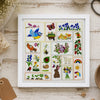 Framed embroidered art with various designs on a wooden surface with crafting supplies.