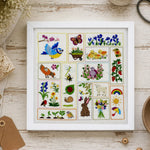 Framed embroidered art with various designs on a wooden surface with crafting supplies.