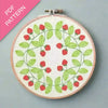 Embroidery hoop with strawberry pattern on a gray background