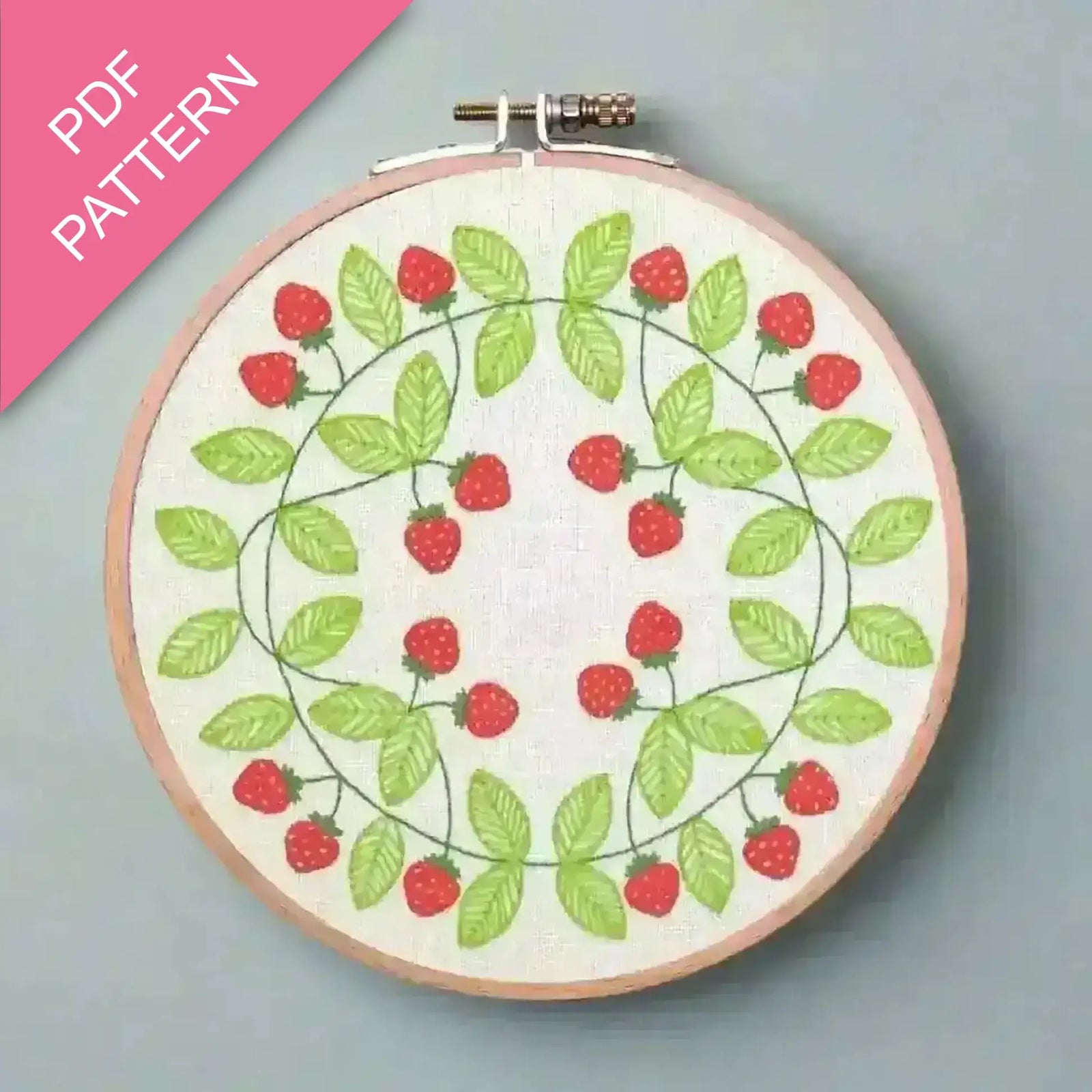Embroidery hoop with strawberry pattern on a gray background