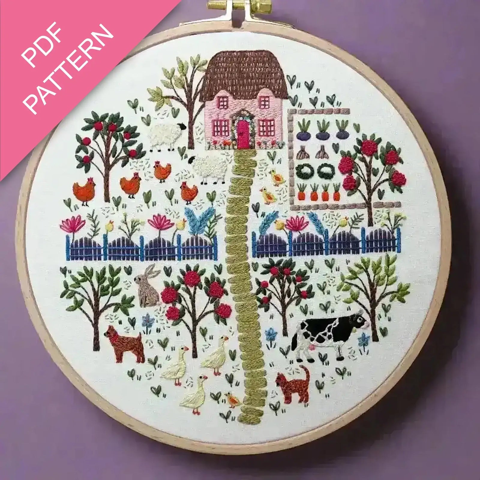 Embroidery hoop with a colorful landscape design on a purple background