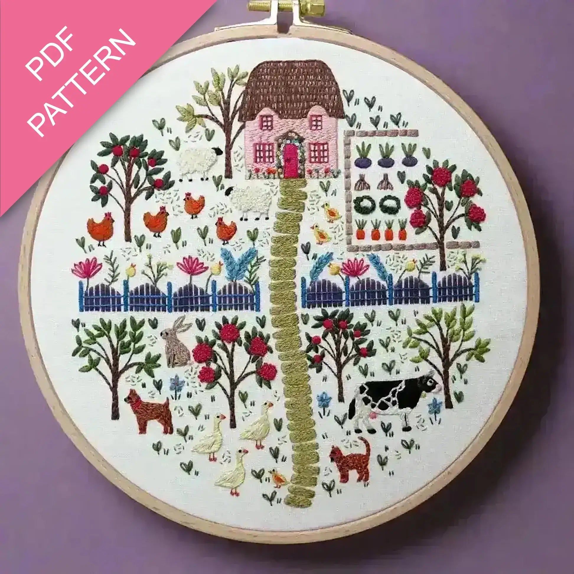 Embroidery hoop with a colorful landscape design on a purple background