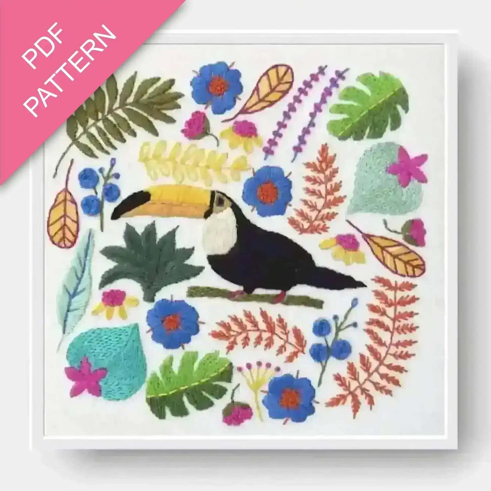 Colorful embroidery pattern with a toucan and tropical leaves on a white background