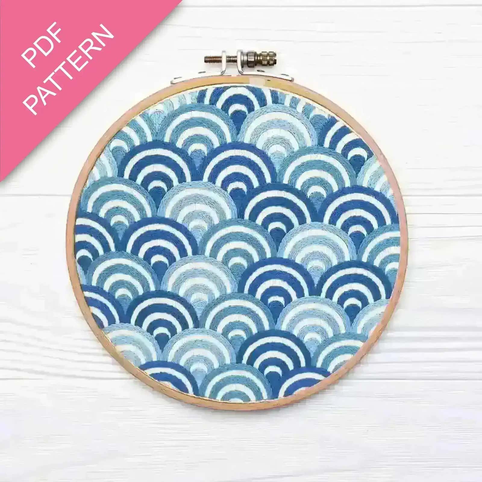 Embroidery hoop with blue and white wave pattern on a white background