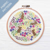 Embroidery hoop with a fabric pattern of bunnies and flowers on a white background