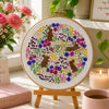 Decorative scene with a floral embroidery hoop, pink mug, and Mother's Day-themed items on a table.