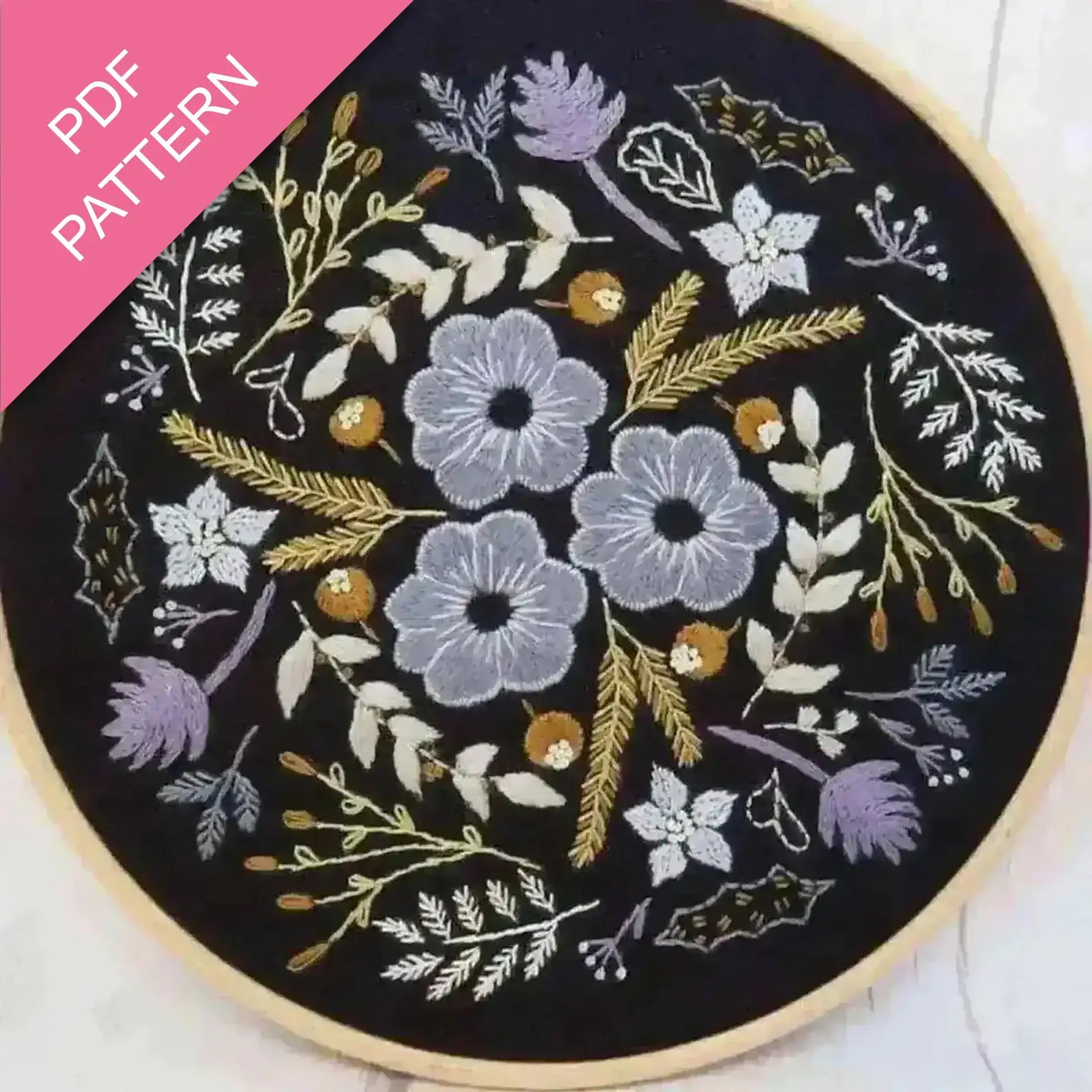 Embroidery hoop with floral pattern on black fabric, PDF pattern text overlay