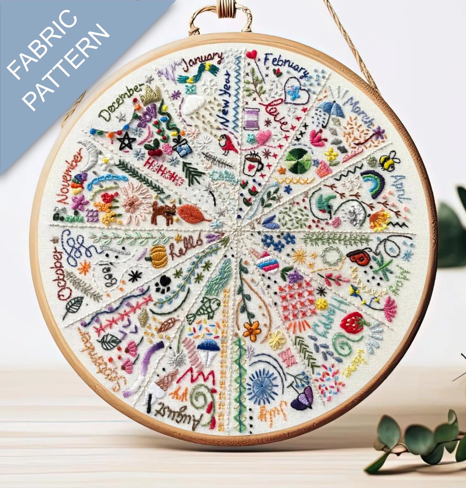 Embroidery hoop with a colorful fabric pattern featuring months of the year.